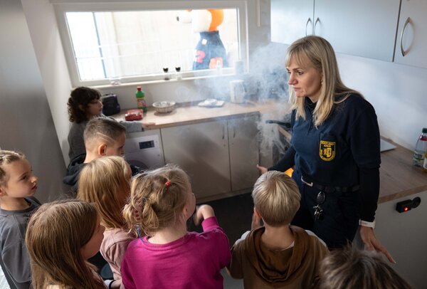Das Bild zeigt Anja Haymann, die vor Kindern erkl&auml;rt, wie man sich in einer verrauchten K&uuml;che richtig verh&auml;lt
